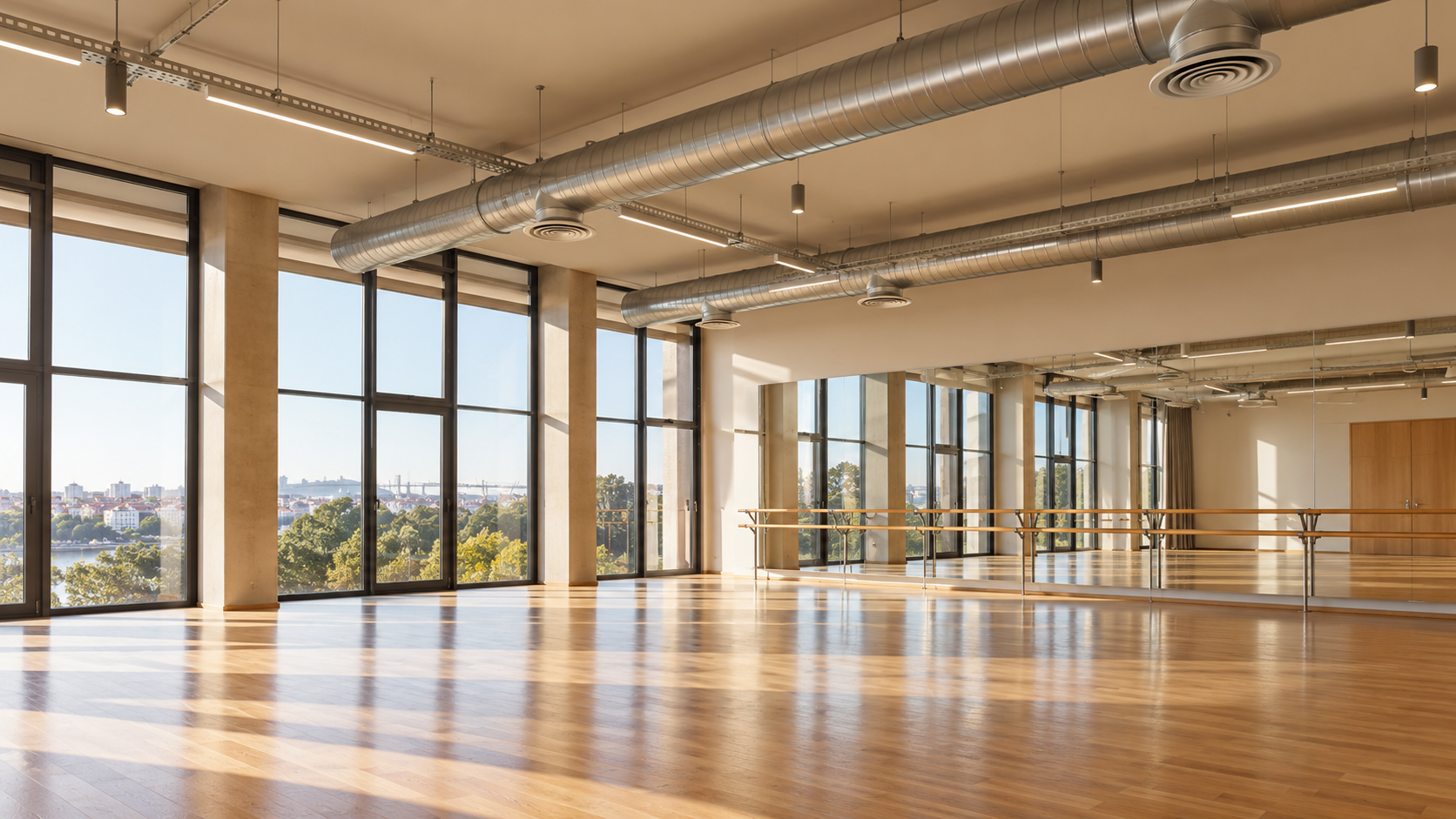 Visualização de um estúdio de dança moderno com espelhos, pavimento em madeira e condutas de ventilação no teto