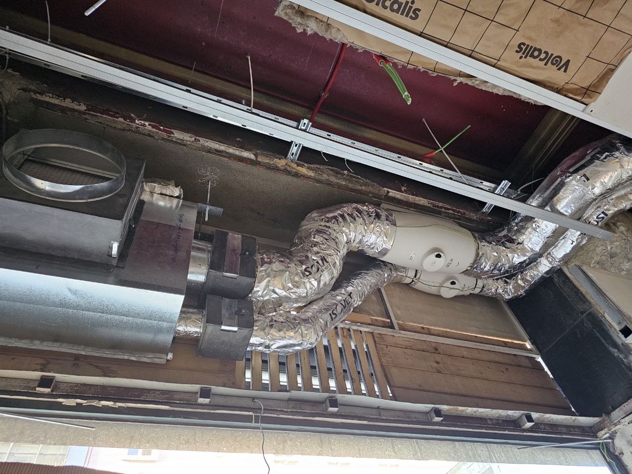 Montagem de ventiladores e condutas isoladas acima do teto