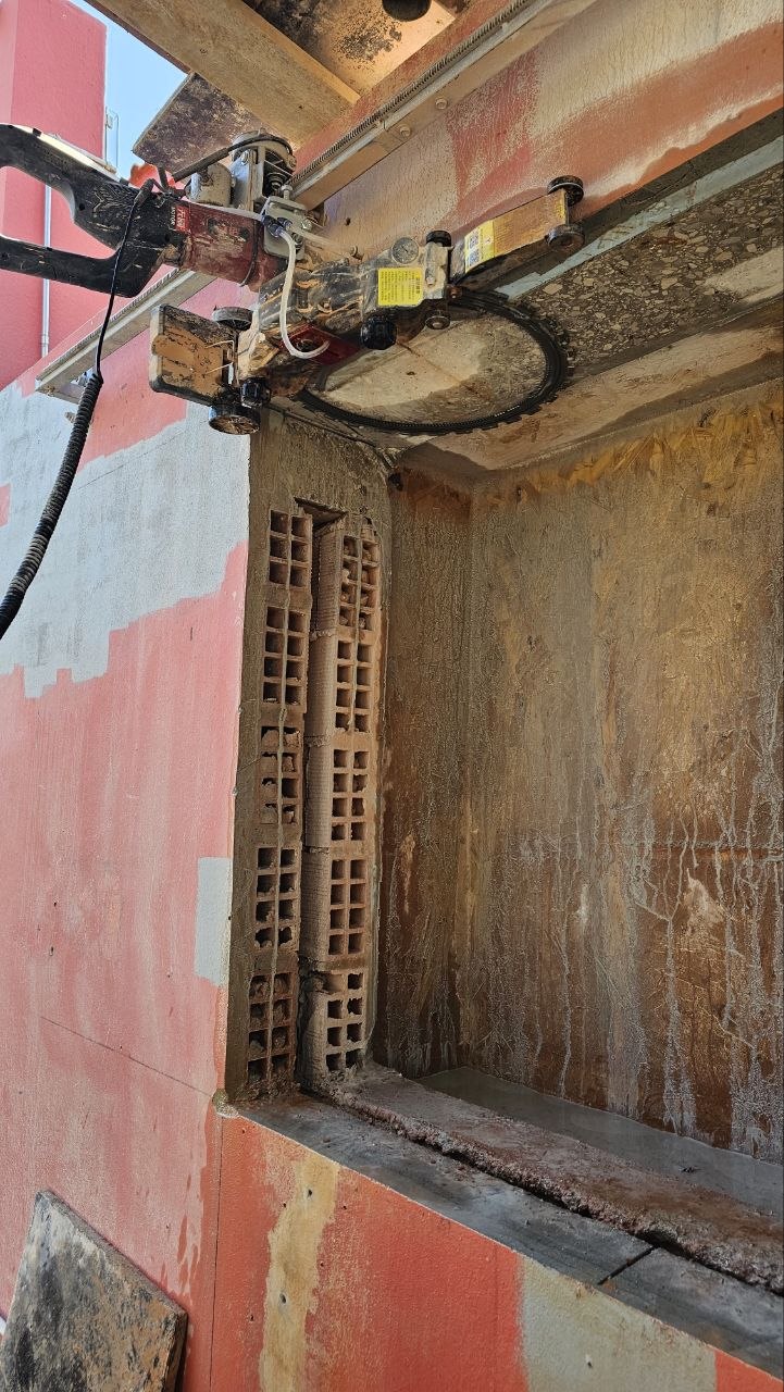 Máquina de corte diamantado montada numa parede durante a abertura de um vão